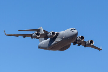 Large four engined military cargo airplane flying. - Powered by Adobe