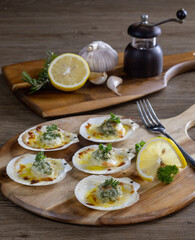Baked Scallops with Cheese on a Wooden Cutting Board