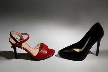 Red and black stiletto heels on gray background