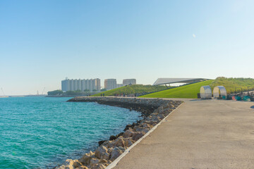 Obraz premium Unidentified man relaxing at green lawn of East Mound-Skyline View park in Doha, Qatar