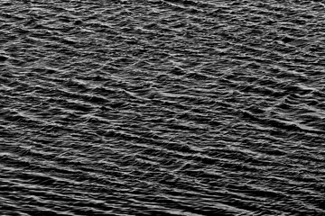 An abstract image in monochrome of ripples on water creating a pattern which can be used for background or tiles or writing a message