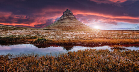 Scenic image of Iceland. The Kirkjufell volcano the coast of Snaefellsnes peninsula with dramatic, colorful sky during sunset. Majestic Kirkjufell (Church mountain) the most famous icelandic landmark © jenyateua