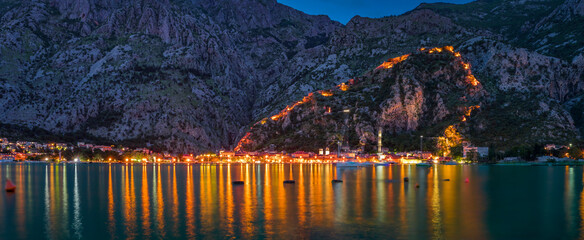 Sunset of Kotor Bay or Boka Kotorska with an illuminated ancient fortress city wall in the...