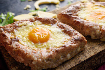 Fragrant khachapuri with cheese, egg, whole grain flour, cottage cheese on a wooded cottage. Proper food, and a delicious breakfast