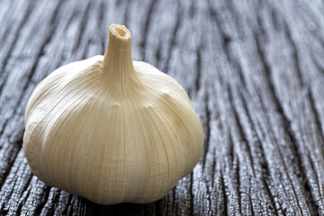 Raw garlic on dark wooden background.