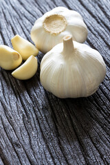 Fresh Garlic Bulb and Cloves on dark wooden background..