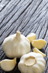 Fresh Garlic Bulb and Cloves on dark wooden background..