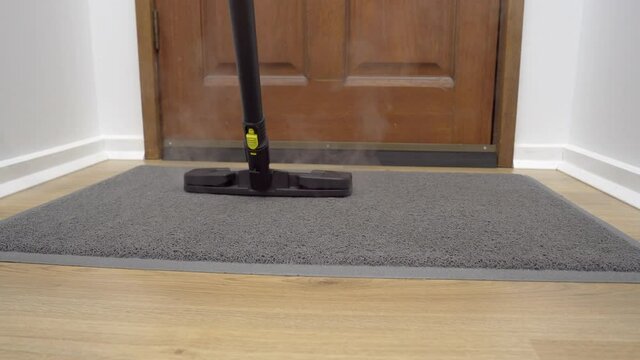 Motorized dolly shot of sanitizing front doormat with steam cleaner