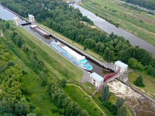 Aerial view river passenger ship passes through locks on the river channel. Tourist routes on rivers and canals