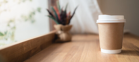 Take away coffee cup with lipstick mark on wooden table in coffee cafe. Panoramic banner portion