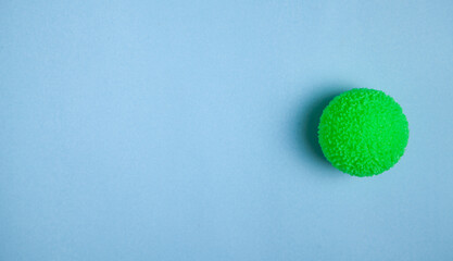 Green stress ball on blue background.