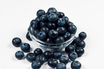 Freshly juicy picked blueberries in glass bowl isolated on white background. 