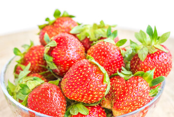 Strawberries in a plate on the table on a white background.