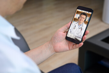 an Asian doctor who is remotely consulting with a patient. Telehealth concept