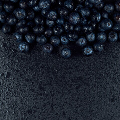 Freshly juicy picked blueberries on dark background. Top view. Selective focus. 