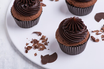 chocolate cupcake on white plate, top view, close-up