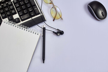 White office desk table with blank, computer keyboard and other office supplies. Top view with copy space, flat lay.