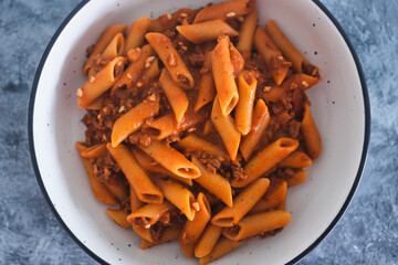 plant-based food, vegan penne pasta with red pesto and bean bolognaise sauce