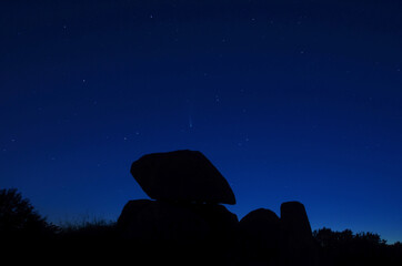 Night landscape with iron age barrow at midnight with comet Neowise in the sky
