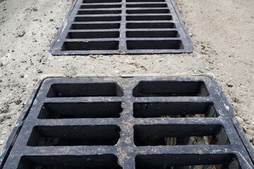 New rainwater grate on the road or sidewalk, installation in concrete. City sewage system for draining water during heavy rain