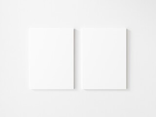 Two empty vertical canvas frame on white wall. 3d illustration.