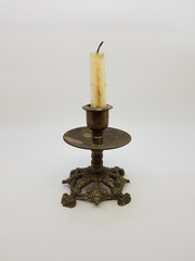 Candle in a candlestick, vintage candle holder on a white background