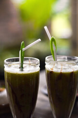 2 Fresh avocado juice in a glass with the addition of liquid chocolate milk and plastic straws