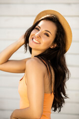 Beautiful brunette girl in a straw hat looking happy