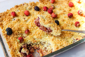 Ruddy crumble with field strawberries, decorated with a sprig of mint