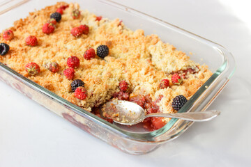 Ruddy crumble with field strawberries, decorated with a sprig of mint