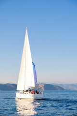 Fototapeta premium Racing yacht in the sea on blue sky background. Peaceful seascape. Travel concept, travelling.