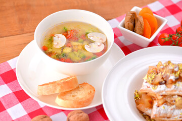 Different food, Italian dishes on the table. Vegetable and meat salad, pasta, soup and puff pastry dessert.
