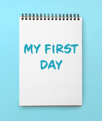 New life beginning. Notebook with text My First Day on light blue background, top view