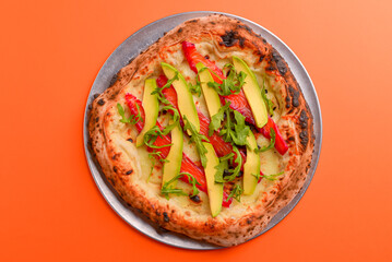 Close-up of a delicious smoked salmon pizza with cheese, avocado and smoked salmon. Sea-food. Orange background.