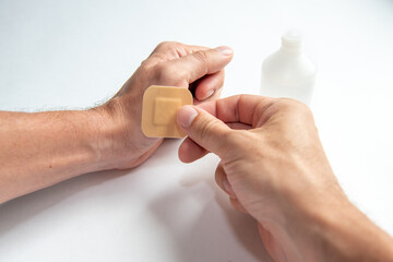 disinfecting the wound on the hand and applying a patch