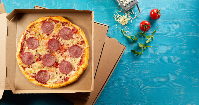 Panorama banner with Italian salami pizza on blue