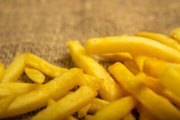 French fries on a homespun fabric with a rough texture. Close up.