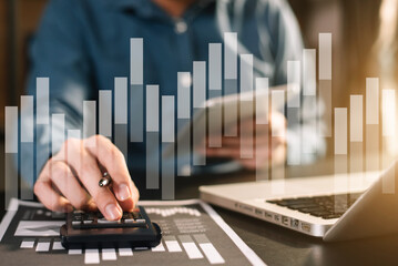 Businessman calculates financials with graph paper on the table on the cost of home office in the...