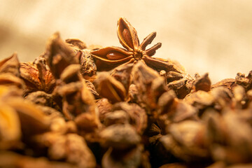 A pile of star anise on a background of burlap with a rough texture surface texture. Close up.