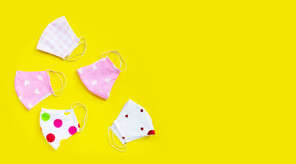 Handmade colorful cloth masks on yellow background.