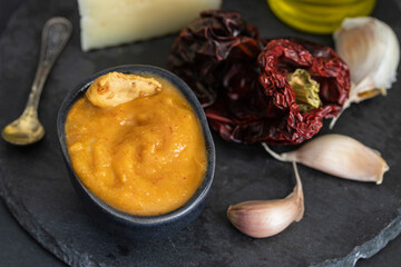 Famous La Gomera Island paste or sauce Almogrote in black bowl  on concrete background.Close up