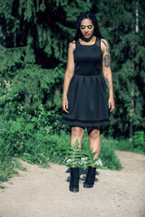 Portrait of a young beautiful girl with box braids hairstyle on the nature background