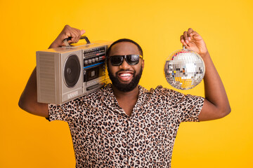 Photo of crazy funny cool dark skin guy hold retro tape recorder glitter disco ball rejoicing...