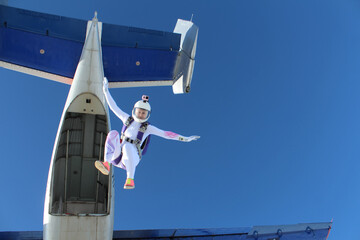 Skydiving. A girl just jumped out of a plane into the blue sky.