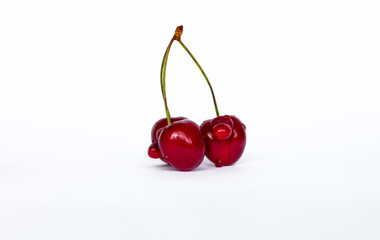 Obraz na płótnie Canvas red defective cherries isolated on white background, ugly food concept, GMO