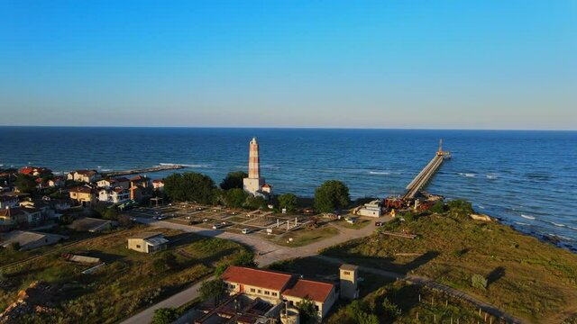 Cinematic aerial footage of lighthouse and a dock in the sea