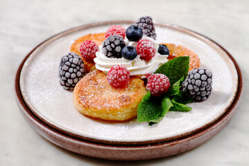a plate with cheese cakes and berries