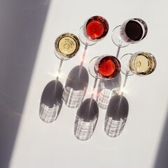 Red, rose and white wine top view in sunlight.