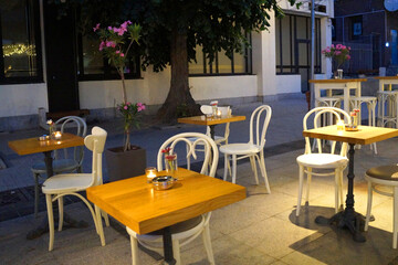 empty tables with candles in street cafe on the central street of Varna in the evening