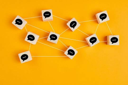 Concept of online communication or social networking. Wooden cubes with speech bubbles linked to each other.